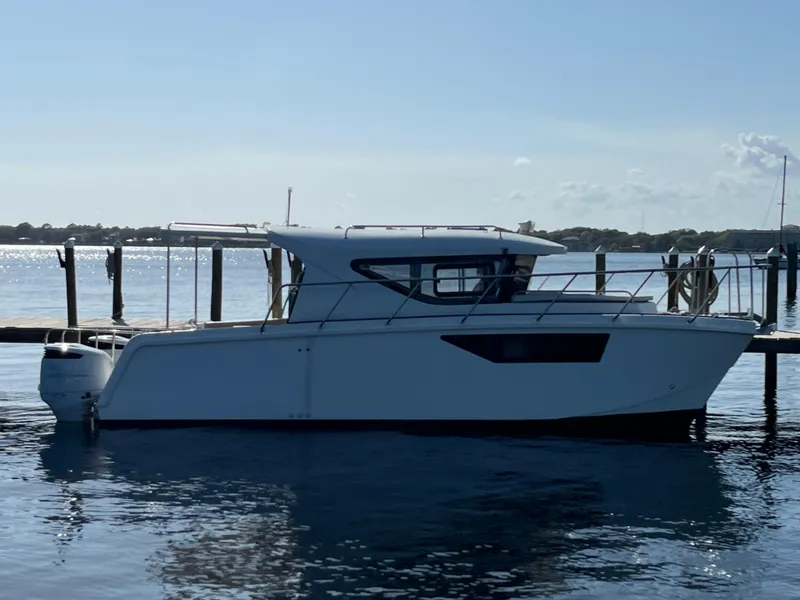 The Image of 2024 Tuna catamaran docked on calm water under clear sky. - 0