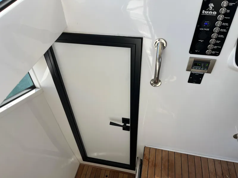 Slide: The Image of 2024 Tuna catamaran interior with sleek door, control panel, and wooden flooring. - 14