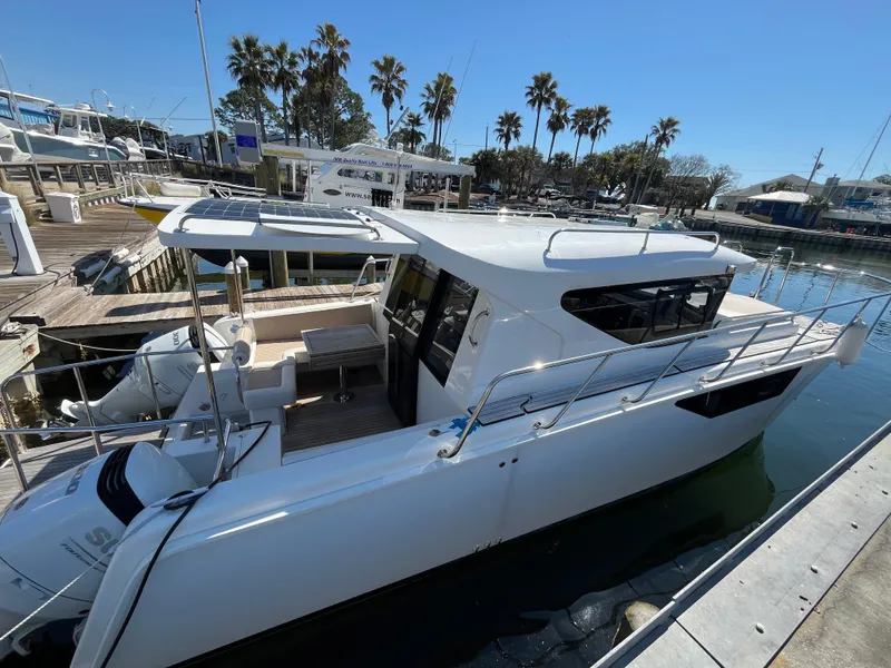 Slide: The Image of 2024 Tuna catamaran docked at marina, surrounded by palm trees and clear blue sky. - 25