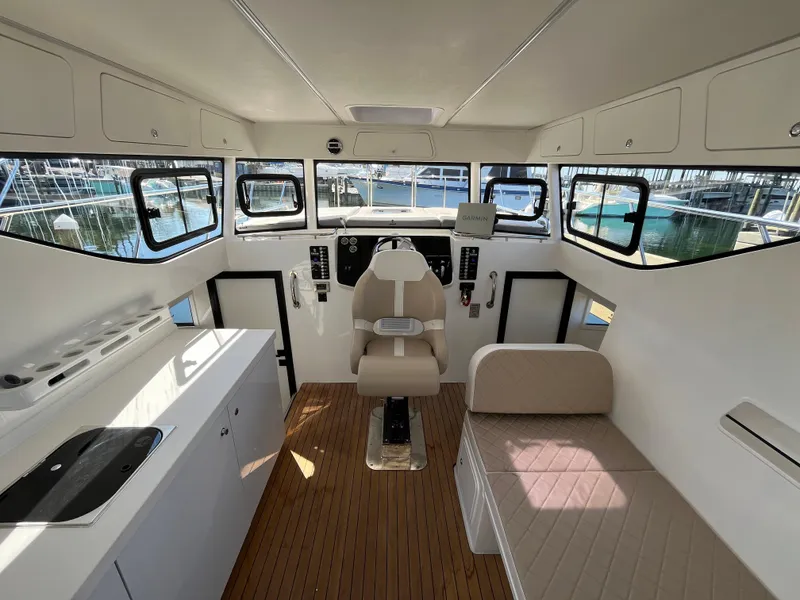 Slide: The Image of 2024 Tuna catamaran interior with helm, seating, and kitchenette, featuring modern design and ample windows. - 4