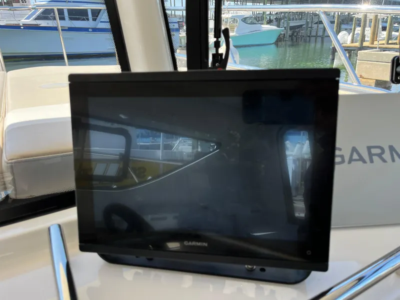 Slide: The Image of Garmin display on 2024 Tuna catamaran, docked with other boats in the background. - 7