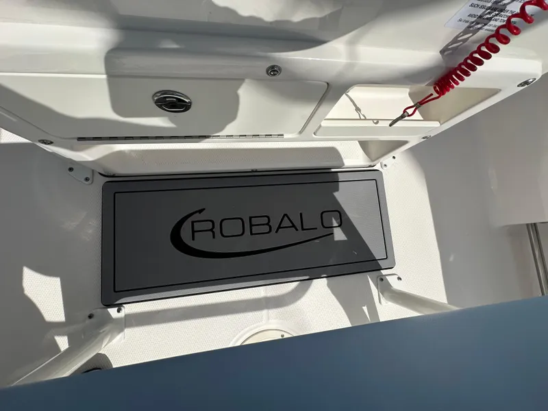 Slide: The Image of 2023 Robalo R202EX boat interior with branded flooring and storage compartments. - 11