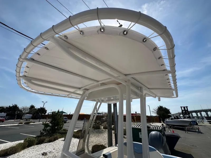 Slide: The Image of 2023 Robalo R202EX boat with a white T-top canopy in a marina setting. - 18