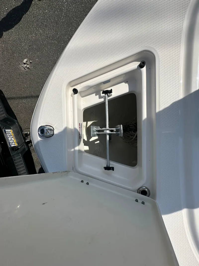Slide: The Image of 2023 Robalo R202EX boat anchor compartment with open hatch, showing anchor storage. - 20