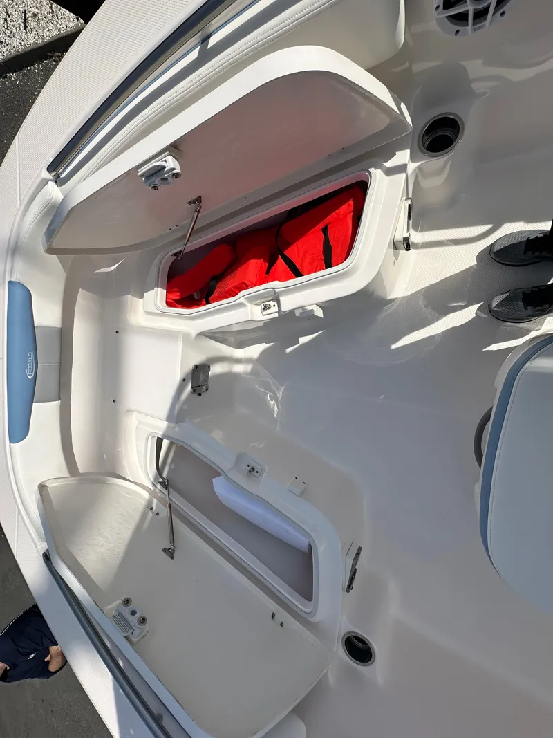 Slide: The Image of 2023 Robalo R202EX boat interior with open storage compartments and red life jackets. - 21