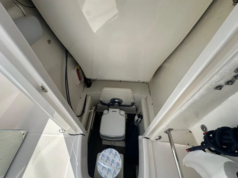 Slide: The Image of 2023 Robalo R202EX boat interior with compact marine toilet. - 26