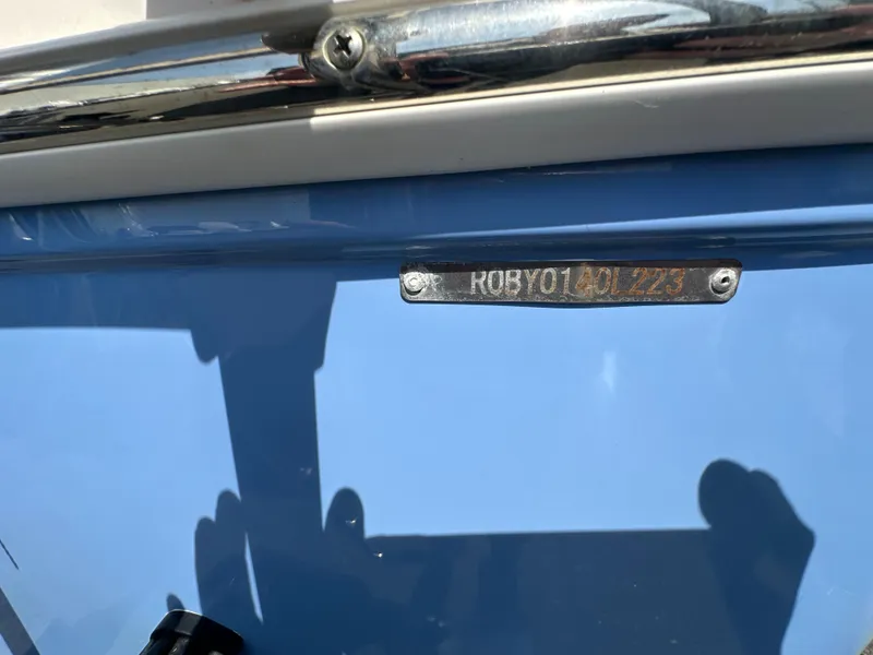 Slide: The Image of 2023 Robalo R202EX boat with identification plate on blue hull. - 28