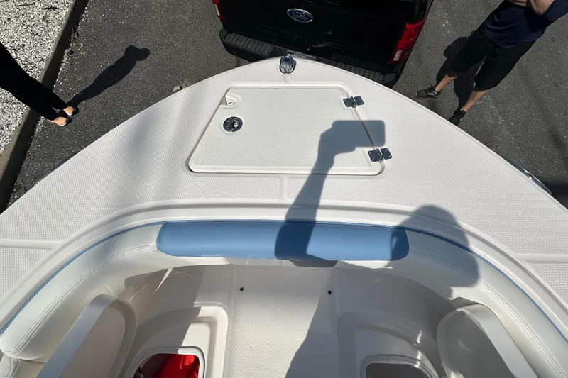 Slide: The Image of 2023 Robalo R202EX boat bow with shadow, parked near a black vehicle. - 29