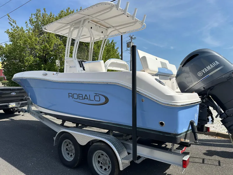 Slide: The Image of 2023 Robalo R202EX boat on trailer with Yamaha engine, parked outdoors. - 8