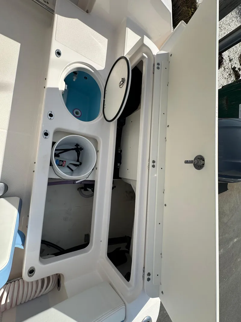 Slide: The Image of 2023 Robalo R202EX boat storage compartments with open lids, showcasing interior design. - 9