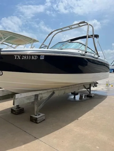 Slide: The Image of 2005 Cobalt 240 boat on dock under clear sky. - 16