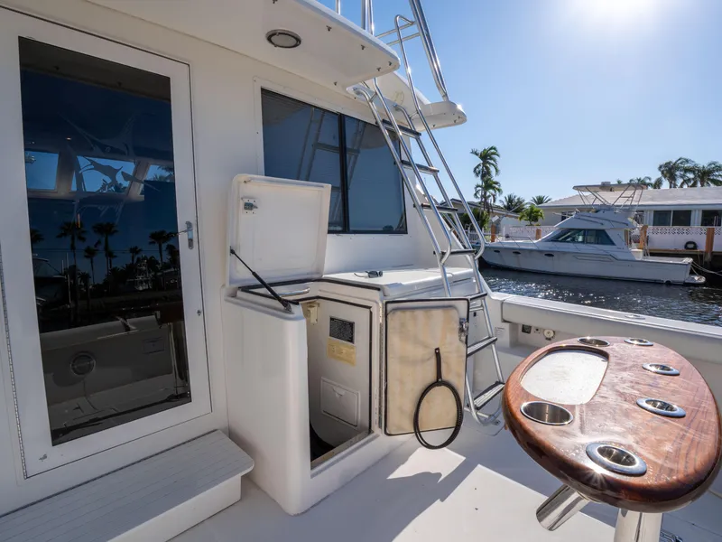 Slide: The Image of 2000 Tiara Yachts 4300 Convertible deck with fishing station and ladder, docked by the water. - 10