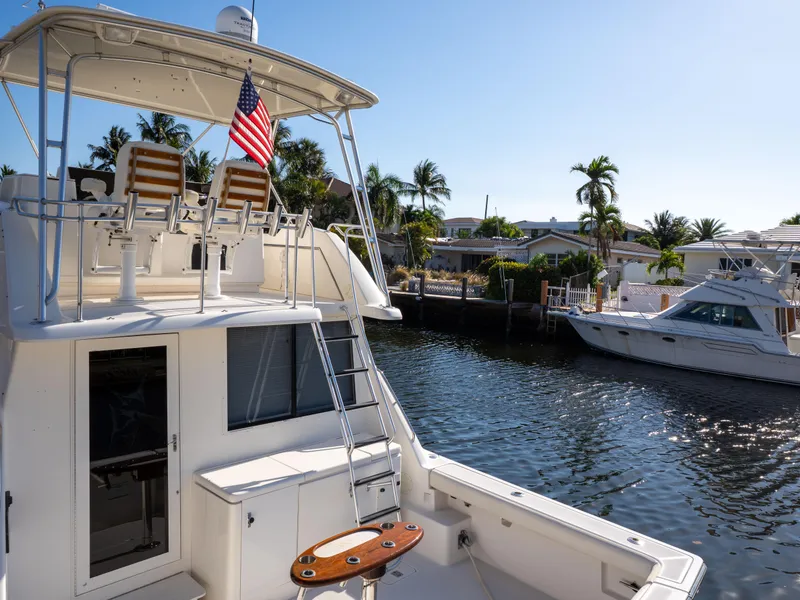 Slide: The Image of Tiara Yachts 4300 Convertible 2000 model docked by a sunny waterfront with palm trees. - 12