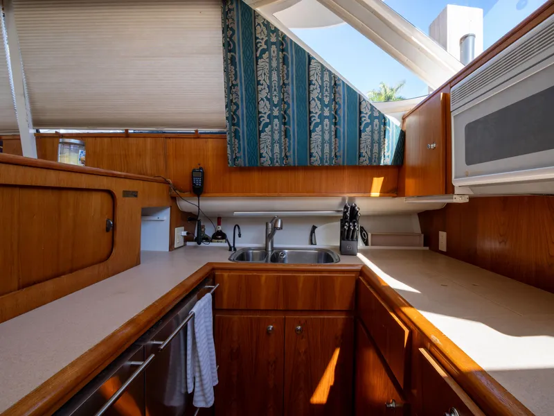 Slide: The Image of Interior of 2000 Tiara Yachts 4300 Convertible, featuring a well-equipped kitchen area. - 19