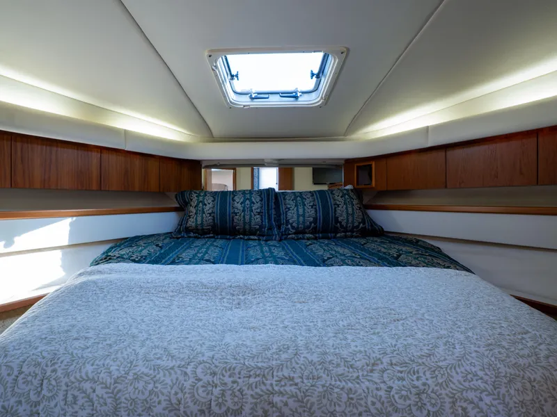 Slide: The Image of Luxurious cabin interior of 2000 Tiara Yachts 4300 Convertible with skylight and cozy bedding. - 25