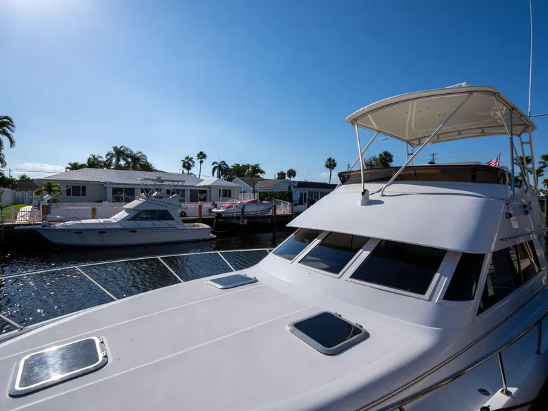 Slide: The Image of 2000 Tiara Yachts 4300 Convertible docked in sunny marina setting. - 26