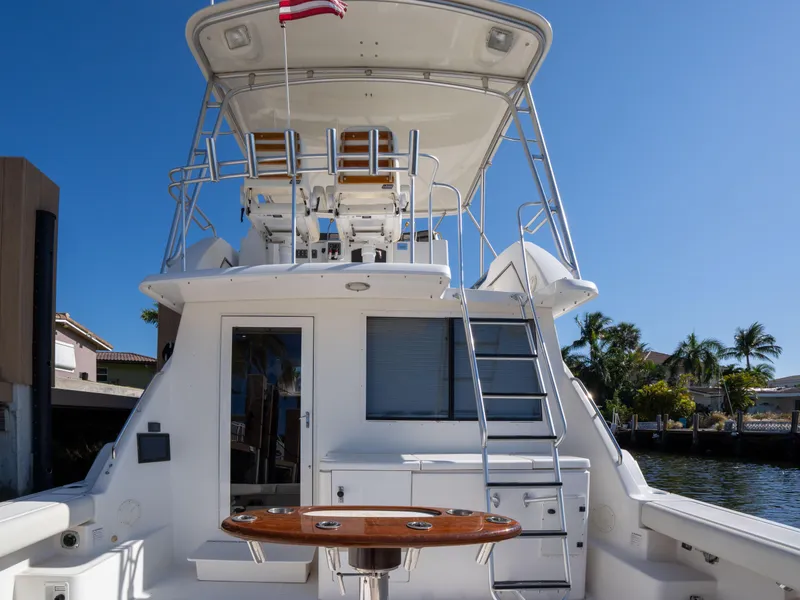 Slide: The Image of 2000 Tiara Yachts 4300 Convertible boat with flybridge, docked under clear blue sky. - 3