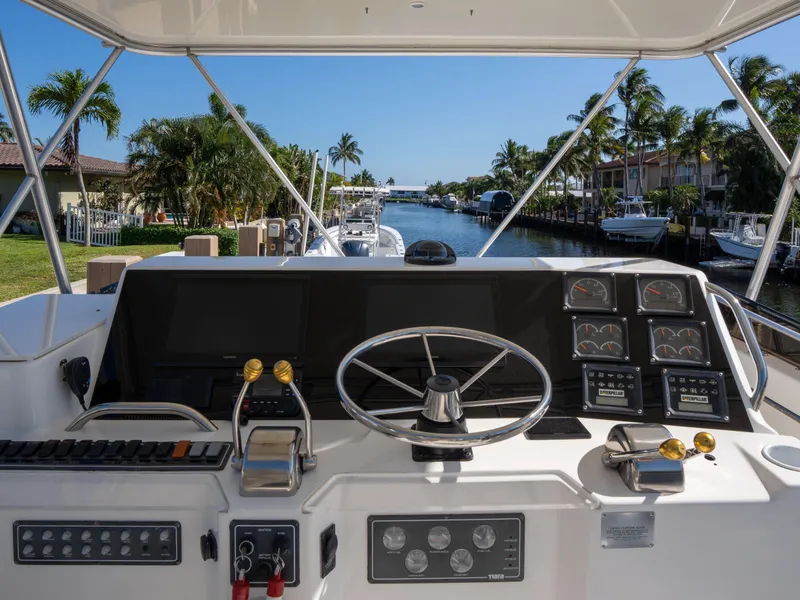 Slide: The Image of Helm of 2000 Tiara Yachts 4300 Convertible overlooking a scenic waterway. - 5