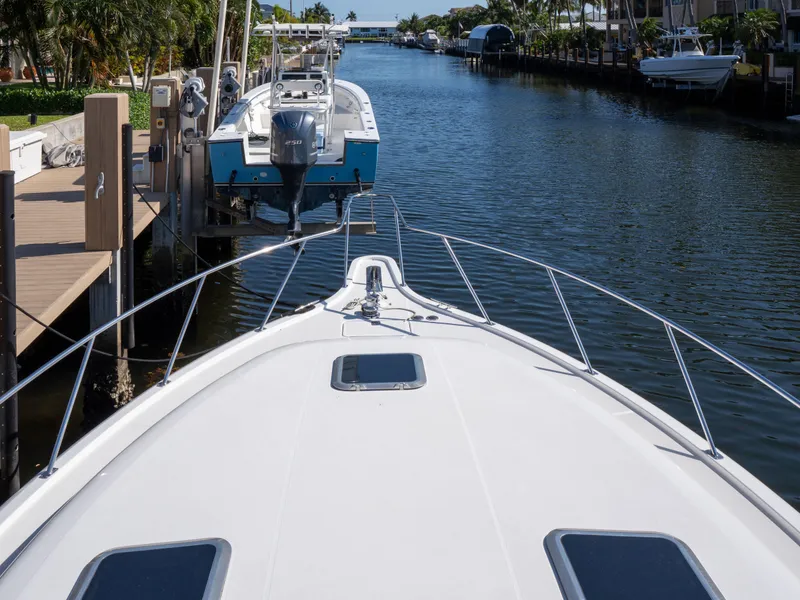 Slide: The Image of Bow view of 2000 Tiara Yachts 4300 Convertible docked in a serene canal. - 8