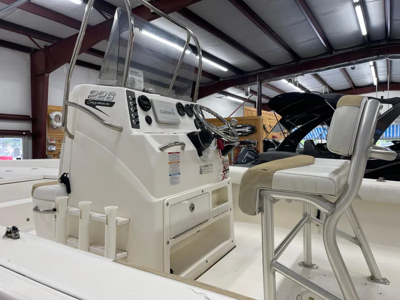 Slide: The Image of 2015 Robalo 226 Cayman boat interior with steering console and seating in a showroom. - 12