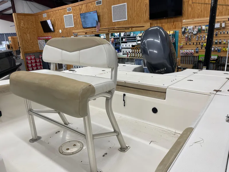 Slide: The Image of 2015 Robalo 226 Cayman boat interior with seating and outboard motor in showroom. - 13