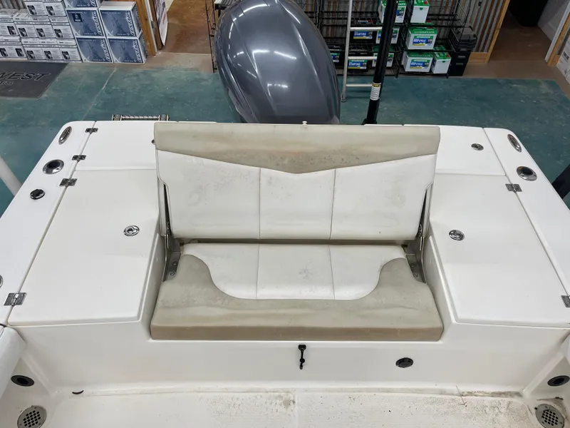Slide: The Image of 2015 Robalo 226 Cayman boat seating area with storage compartments and rod holders. - 14