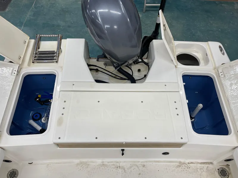 Slide: The Image of 2015 Robalo 226 Cayman boat deck with storage compartments and motor. - 15