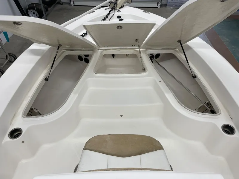 Slide: The Image of 2015 Robalo 226 Cayman boat storage compartments open, showcasing spacious interior design. - 20