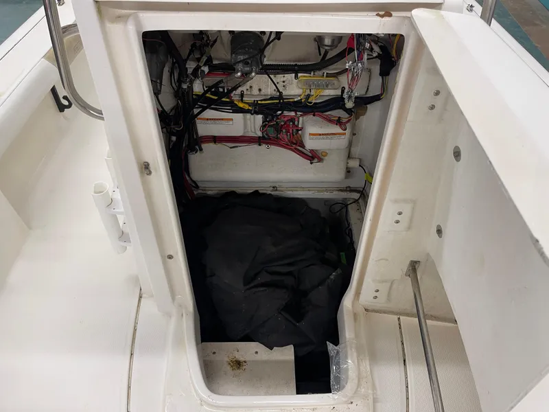 Slide: The Image of 2015 Robalo 226 Cayman boat storage compartment with wiring and equipment. - 22