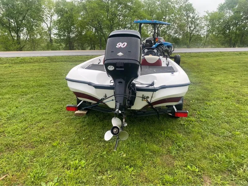 Slide: The Image of 2006 Nitro 750 boat with outboard motor on grassy area, trees in background. - 3