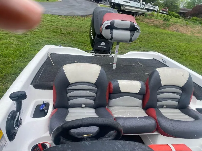 Slide: The Image of 2006 Nitro 750 boat interior with red and gray seats on grassy area. - 5