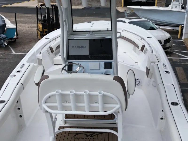 Slide: The Image of 2025 Tidewater 232LXF boat interior with Garmin navigation system, white seating, and steering wheel. - 17