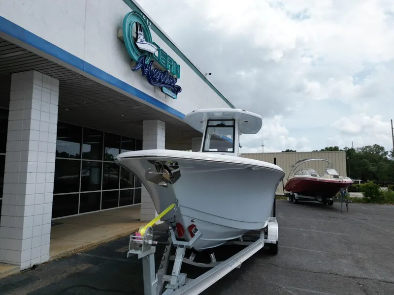 Slide: The Image of 2025 Tidewater 232LXF boat on trailer outside a marine dealership. - 8