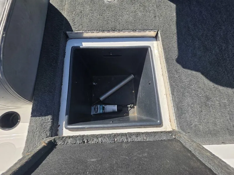 Slide: The Image of Open storage compartment in 1999 Generation III G3 Fiberglass boat, featuring carpeted interior. - 13