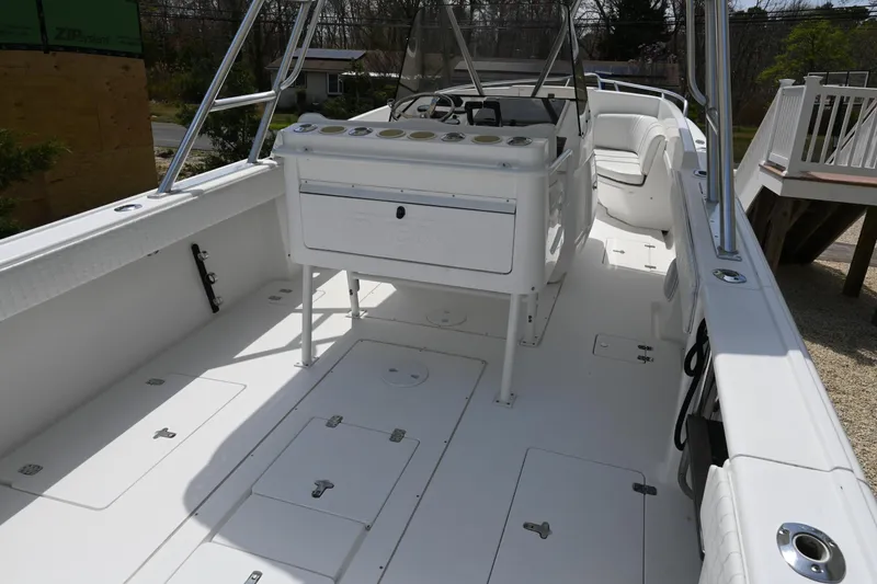 Slide: The Image of 2002 Intrepid 323 Cuddy boat deck with seating and storage compartments. - 19