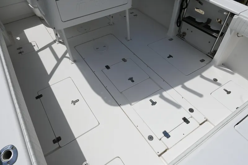Slide: The Image of 2002 Intrepid 323 Cuddy boat deck with storage compartments and seating area. - 21