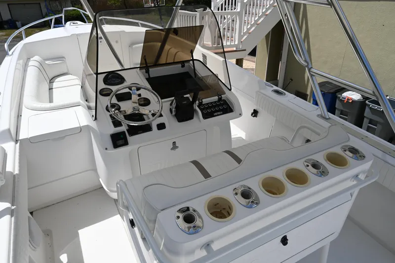Slide: The Image of 2002 Intrepid 323 Cuddy boat interior with steering console and seating area. - 23