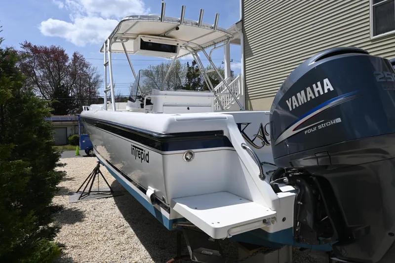 Slide: The Image of 2002 Intrepid 323 Cuddy boat with Yamaha engine, parked outdoors. - 3