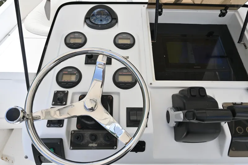 Slide: The Image of 2002 Intrepid 323 Cuddy dashboard with steering wheel and control gauges. - 30