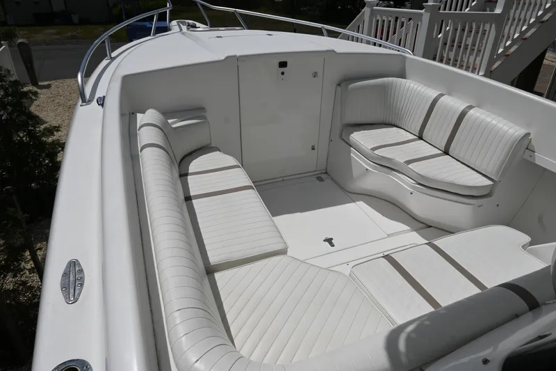 Slide: The Image of 2002 Intrepid 323 Cuddy boat interior with white cushioned seating. - 33