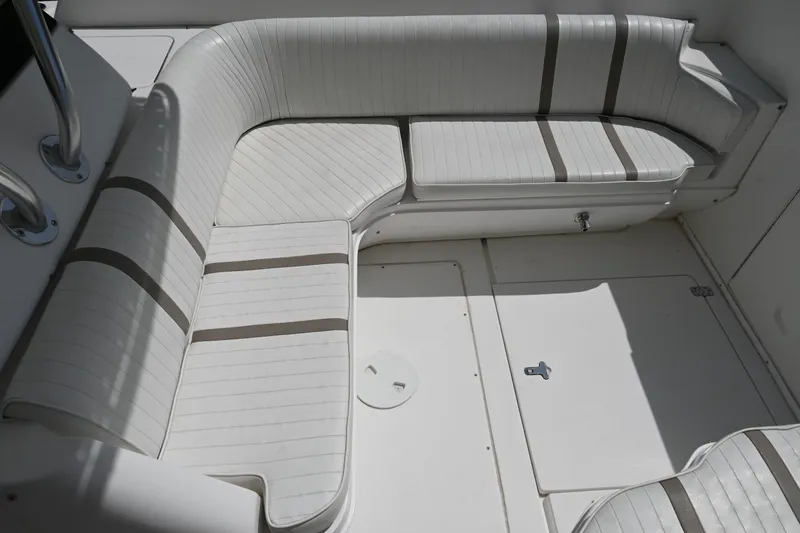 Slide: The Image of 2002 Intrepid 323 Cuddy boat interior with white cushioned seating. - 36