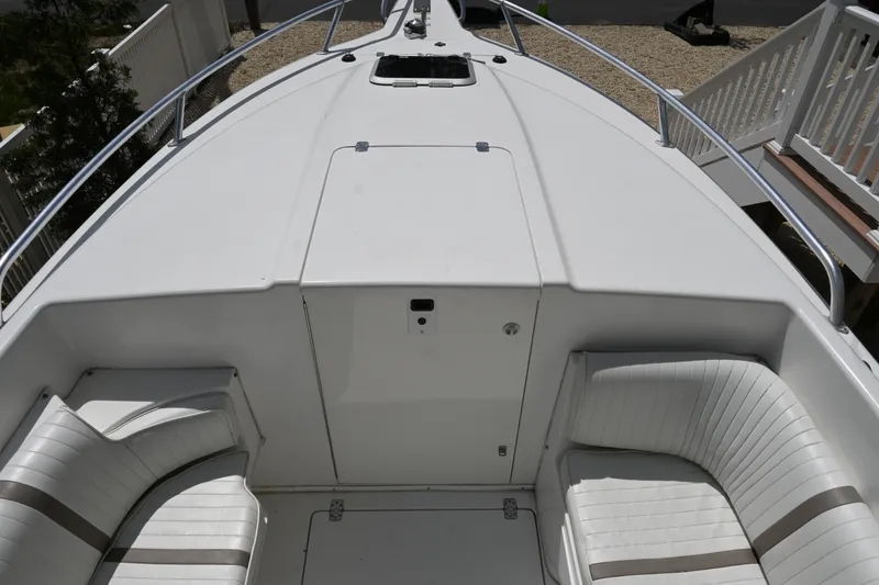 Slide: The Image of 2002 Intrepid 323 Cuddy boat deck with white seating and sleek design. - 37