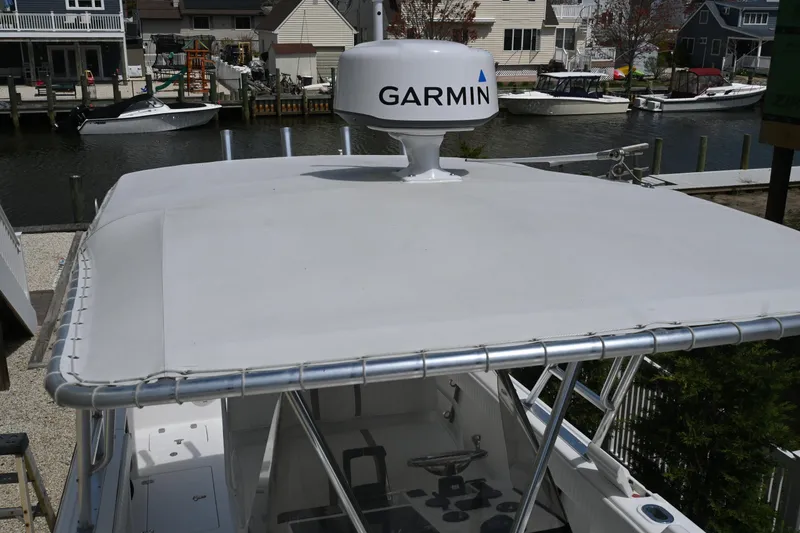Slide: The Image of 2002 Intrepid 323 Cuddy boat with Garmin radar, docked in a residential marina. - 43