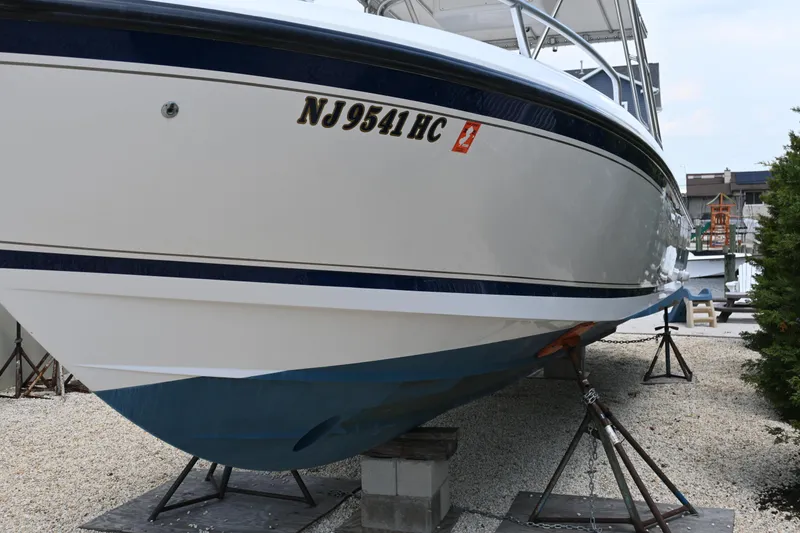 Slide: The Image of 2002 Intrepid 323 Cuddy boat on stands, displaying registration number NJ 9541 HC. - 7