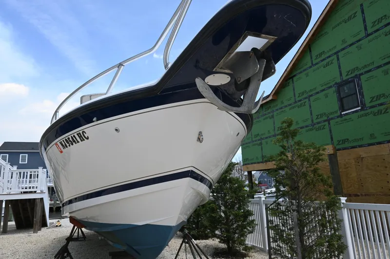 Slide: The Image of 2002 Intrepid 323 Cuddy boat on dry dock near a house under construction. - 9