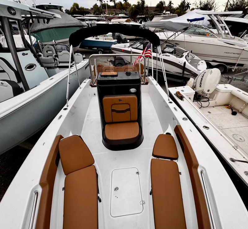 Slide: The Image of 2025 Sea Pro 202 Center Console boat with tan seating, docked among other boats. - 16