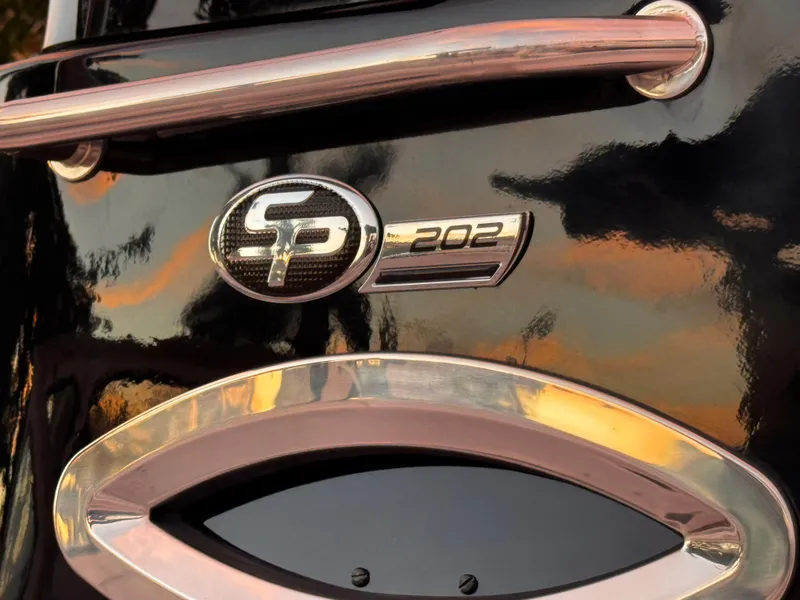 Slide: The Image of 2025 Sea Pro 202 Center Console emblem on glossy black surface, reflecting sunset colors. - 28