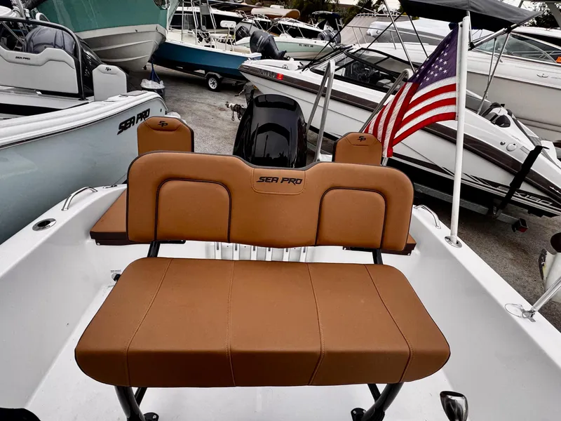 Slide: The Image of 2025 Sea Pro 202 Center Console boat with tan seating and American flag. - 9