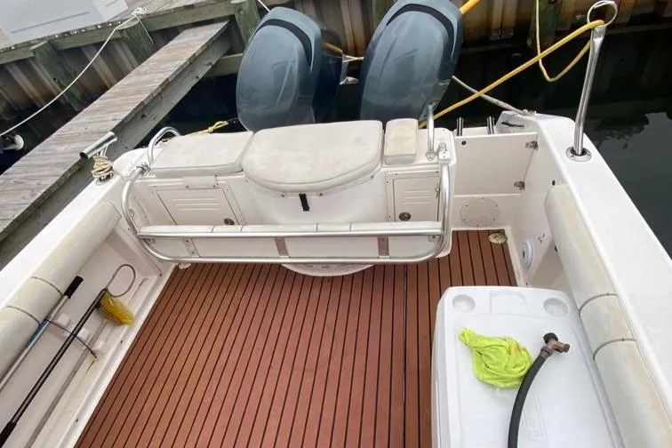 Slide: The Image of 2004 Cobia 270 Walk-Around boat with dual engines and wooden deck at dock. - 10