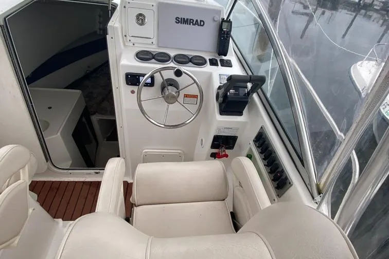 Slide: The Image of 2004 Cobia 270 Walk-Around boat helm with Simrad electronics and comfortable seating. - 4